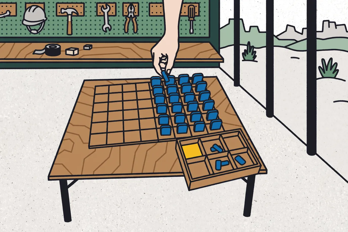 A hand placing upright blue game pieces in the back rows of a grid board next to a sorting tray